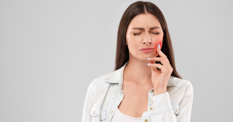 kobieta dotykająca usta z powodu bólu zęba